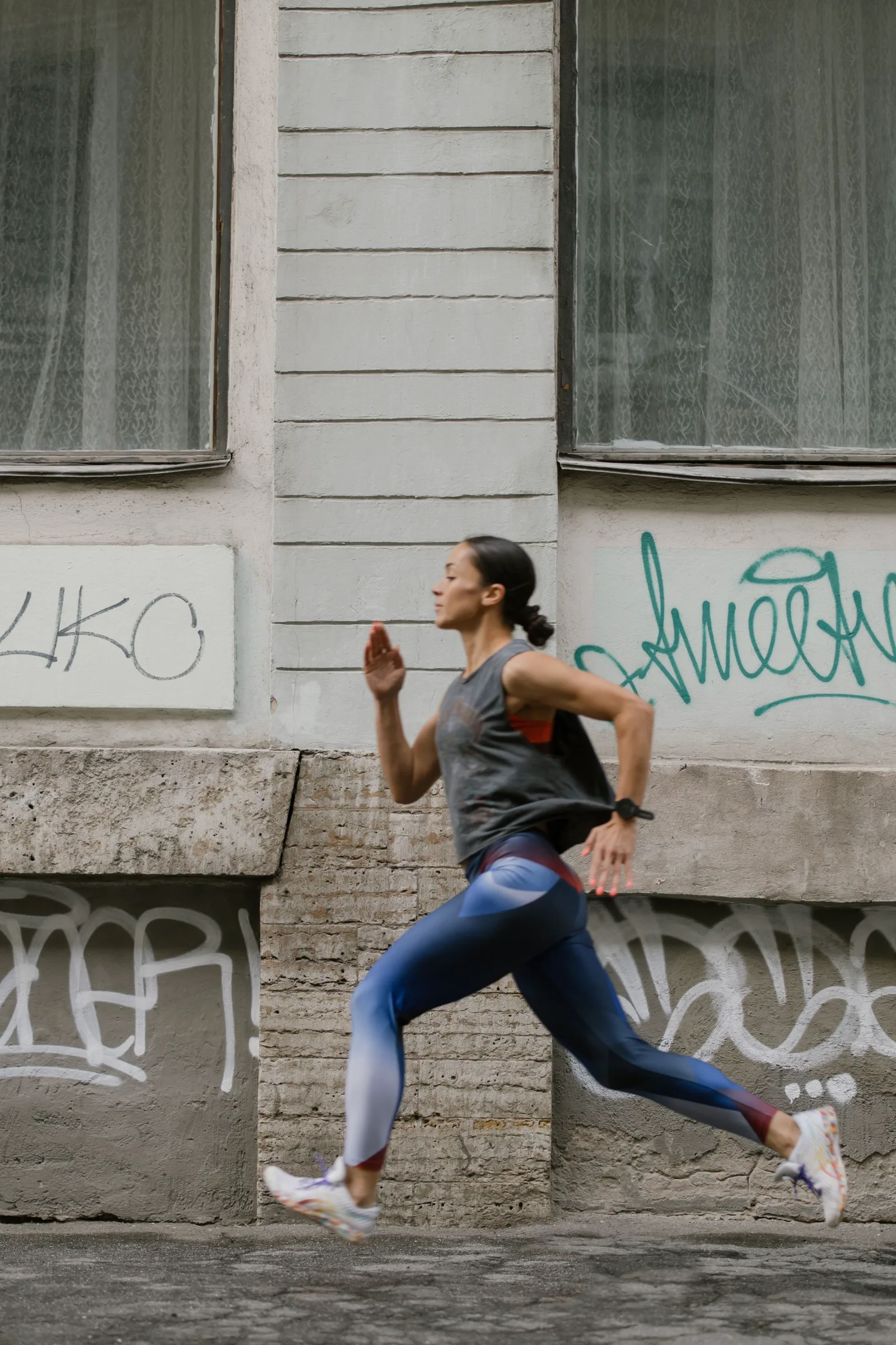 A woman running past a city wall